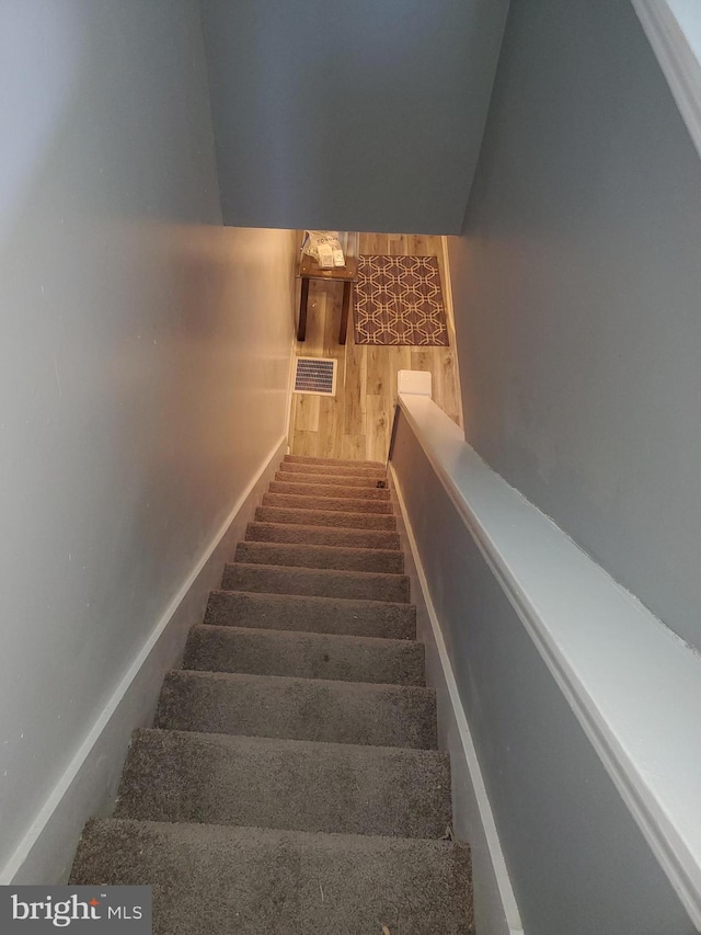 stairway with hardwood / wood-style flooring