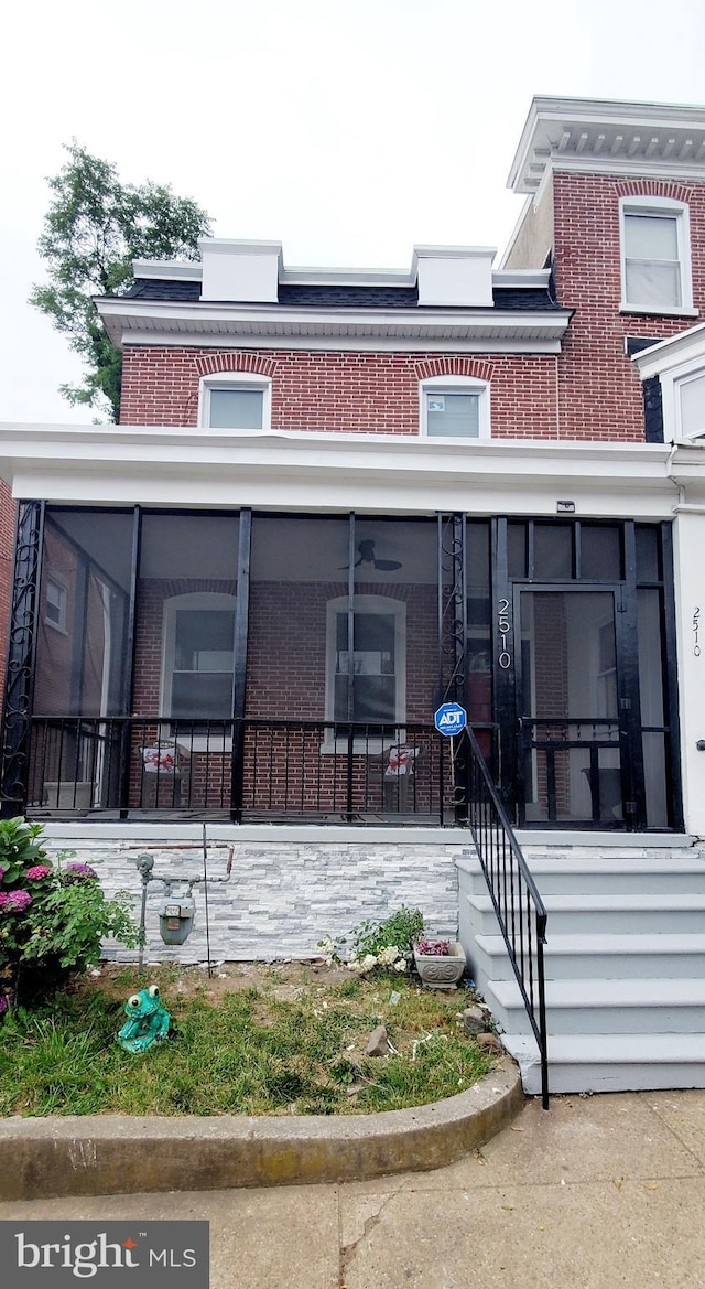 view of front of home featuring a sunroom and a porch