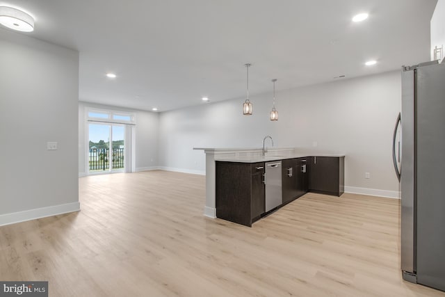 kitchen featuring dark brown cabinets, light hardwood / wood-style floors, and appliances with stainless steel finishes