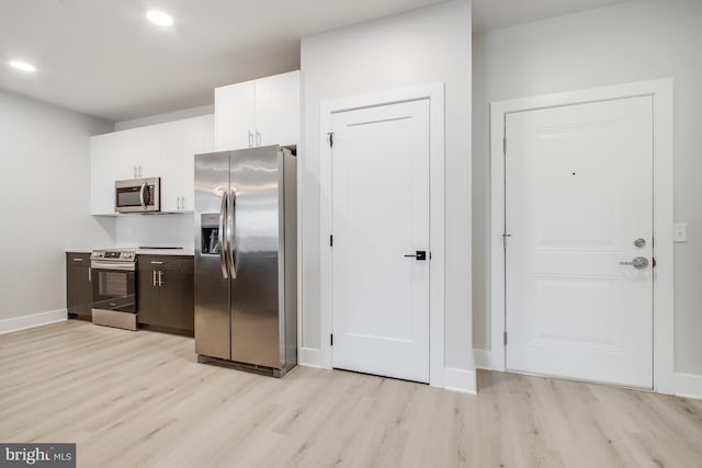 kitchen featuring white cabinets, appliances with stainless steel finishes, and light wood-type flooring