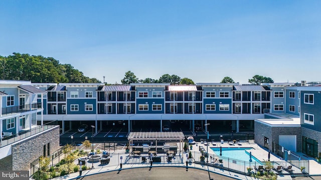 back of house with a patio and a community pool