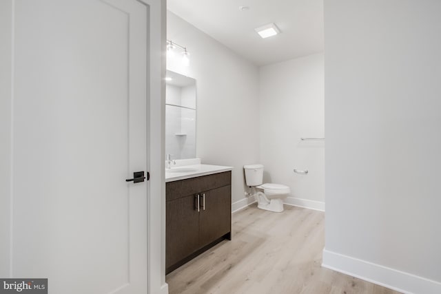 bathroom featuring hardwood / wood-style floors, vanity, and toilet