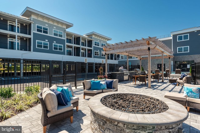 view of patio / terrace featuring a balcony, an outdoor living space with a fire pit, and a pergola