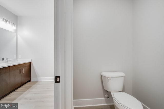 bathroom featuring vanity, toilet, and hardwood / wood-style flooring