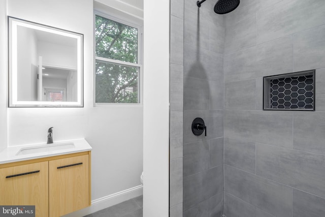 bathroom featuring tiled shower, vanity, and toilet