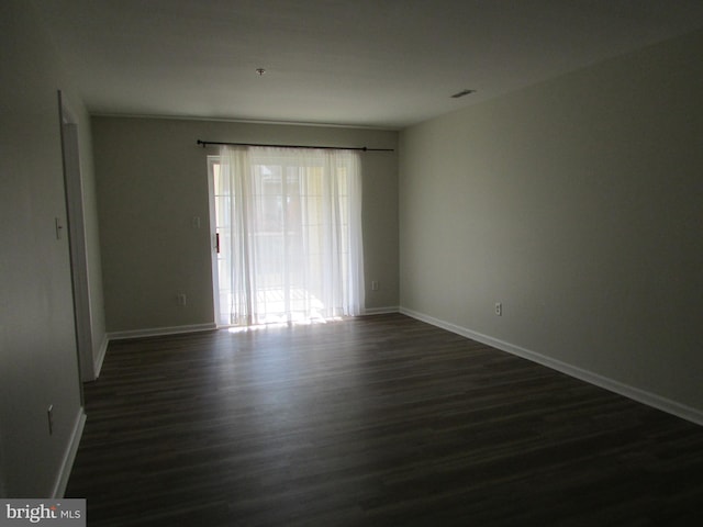 unfurnished room with dark hardwood / wood-style flooring