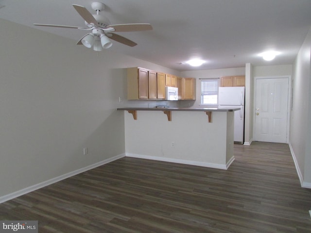 kitchen featuring kitchen peninsula, light brown cabinets, a kitchen bar, dark hardwood / wood-style floors, and white appliances