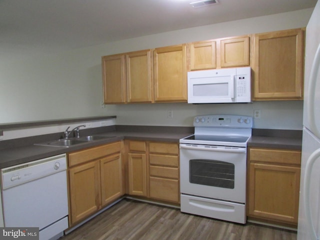 kitchen with white appliances, sink, and dark hardwood / wood-style floors