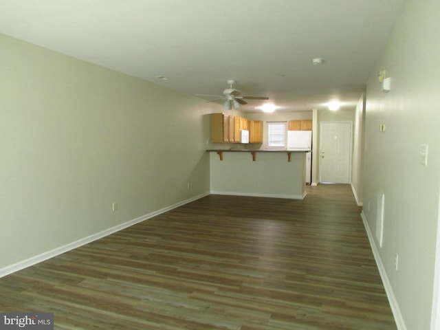 unfurnished living room featuring dark hardwood / wood-style floors and ceiling fan