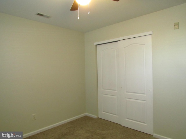 unfurnished bedroom featuring carpet flooring, ceiling fan, and a closet