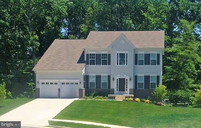 colonial-style house with a front yard and a garage