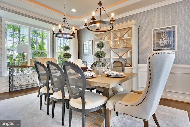 dining room with wood-type flooring, crown molding, and a chandelier