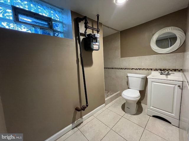 bathroom featuring tile walls, tile patterned flooring, walk in shower, vanity, and toilet