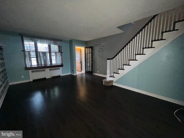 foyer entrance featuring radiator, a textured ceiling, and hardwood / wood-style floors