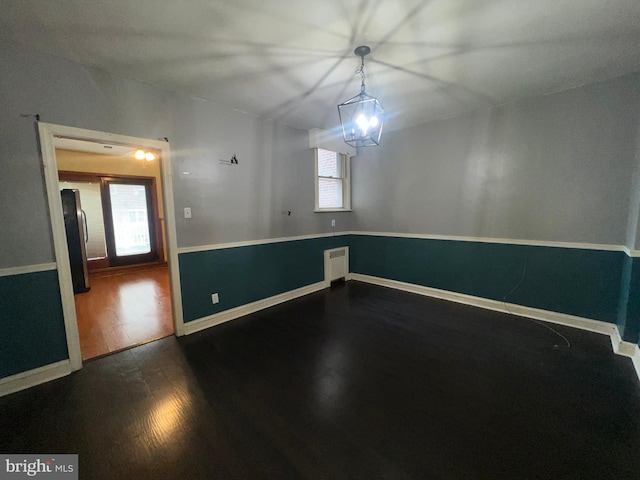 empty room with a healthy amount of sunlight and dark hardwood / wood-style flooring