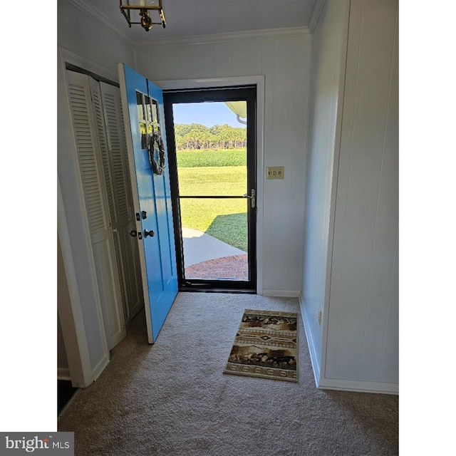 doorway with ornamental molding, carpet floors, and an inviting chandelier