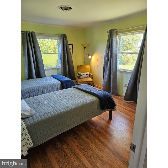 bedroom with wood-type flooring and crown molding