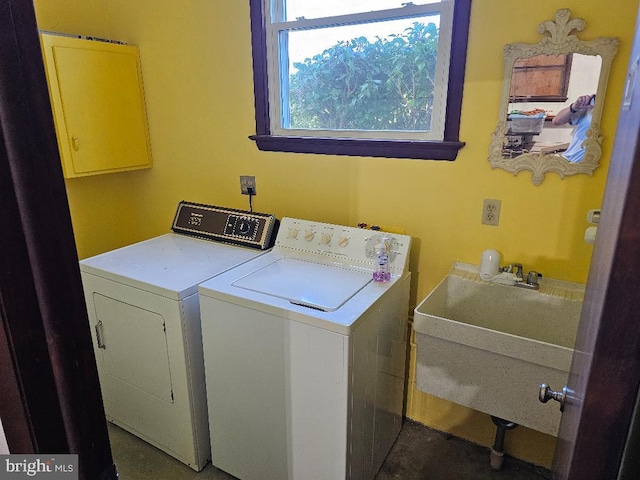 laundry room with cabinets, washer and dryer, and sink