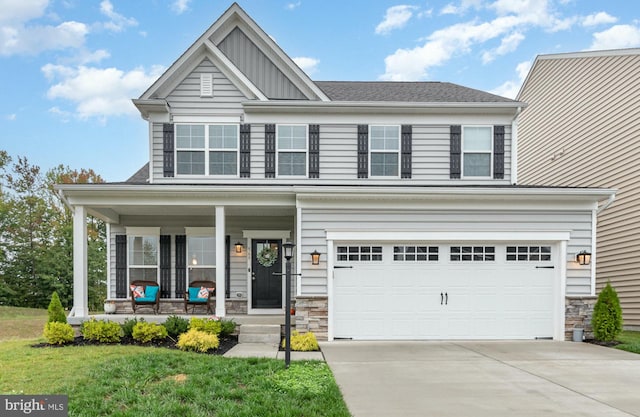 view of front of property with a porch, a garage, and a front yard