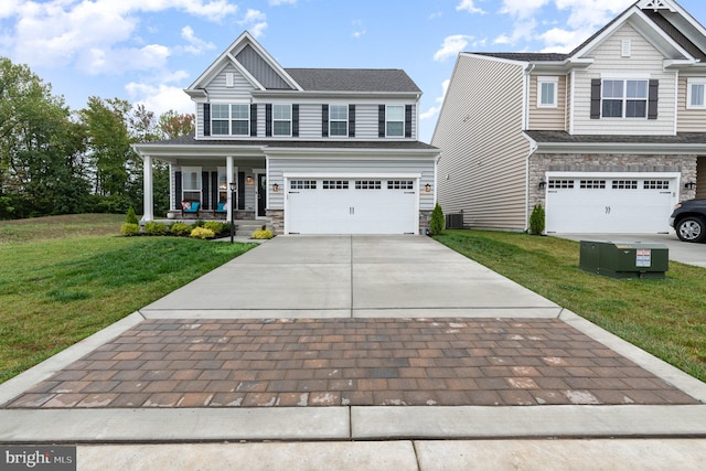 craftsman inspired home featuring cooling unit, a front lawn, a porch, and a garage