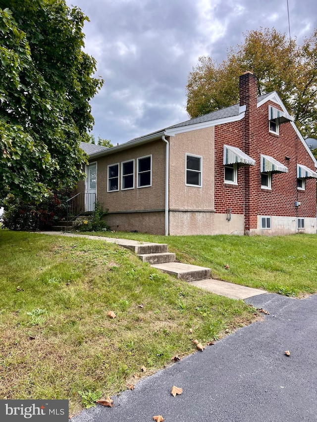 view of side of property with a lawn