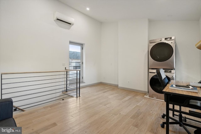 home office featuring a wall mounted air conditioner, light hardwood / wood-style flooring, stacked washer and clothes dryer, and high vaulted ceiling