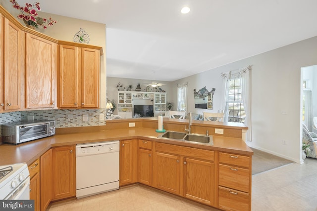 kitchen featuring ceiling fan, tasteful backsplash, white appliances, sink, and kitchen peninsula