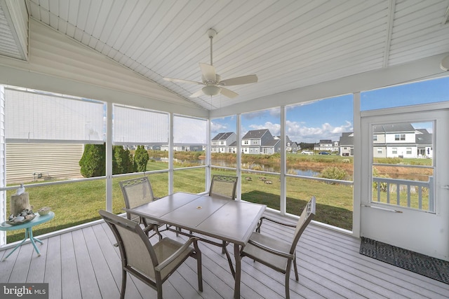 sunroom with ceiling fan, plenty of natural light, vaulted ceiling, and a water view