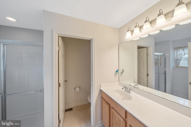 bathroom with vanity, toilet, and an enclosed shower