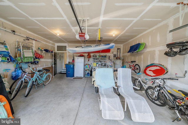 garage with a garage door opener and white fridge