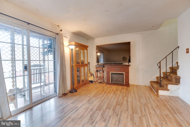 living room featuring light hardwood / wood-style floors and a textured ceiling