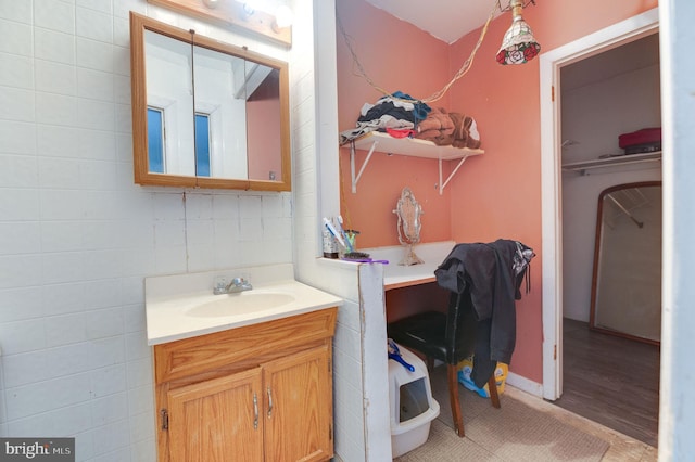 bathroom with vanity, wood-type flooring, and tile walls