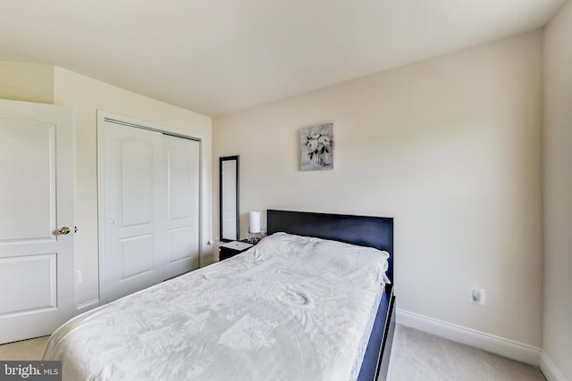 bedroom with a closet and light colored carpet