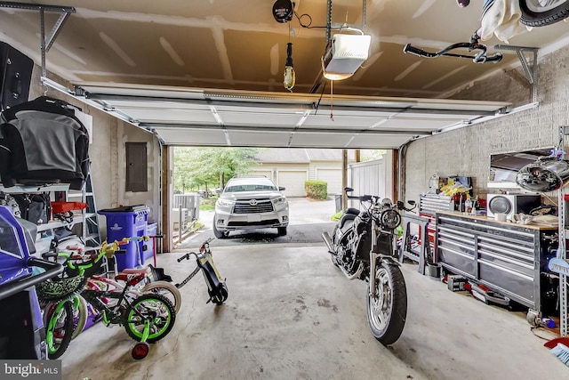 garage featuring electric panel and a garage door opener