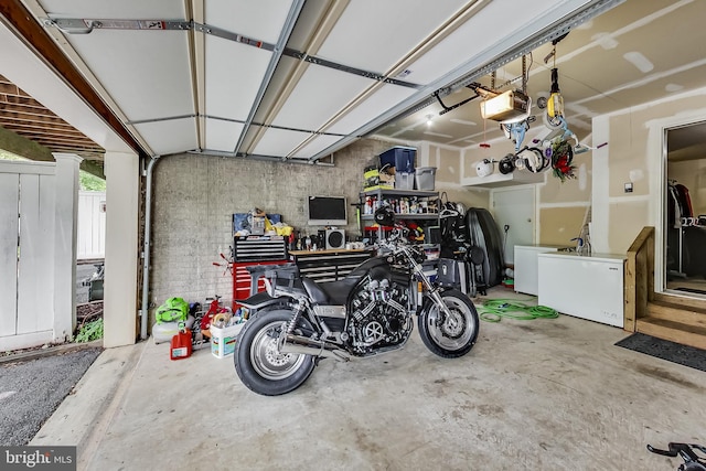 garage with a workshop area and a garage door opener