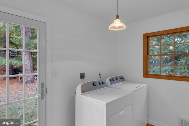 washroom with washing machine and clothes dryer and a wealth of natural light