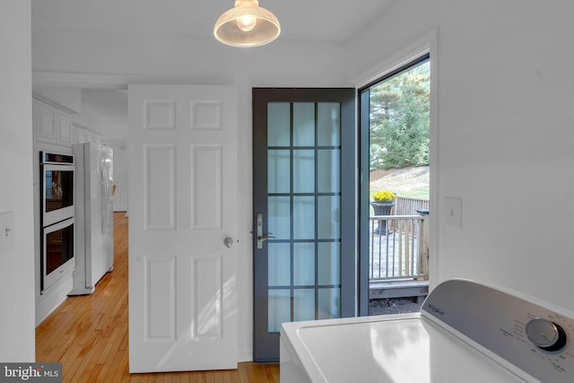 entryway with light hardwood / wood-style floors and washer / dryer