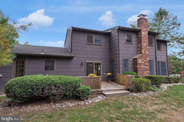 rear view of property with a deck and a yard