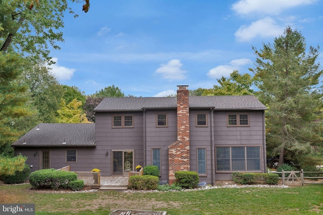 view of front of house with a deck and a front lawn