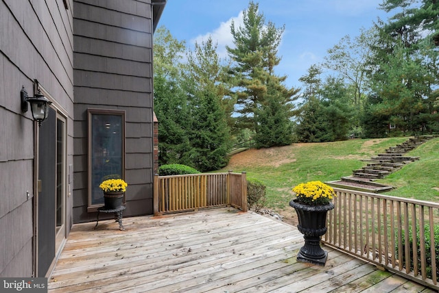 wooden terrace featuring a yard