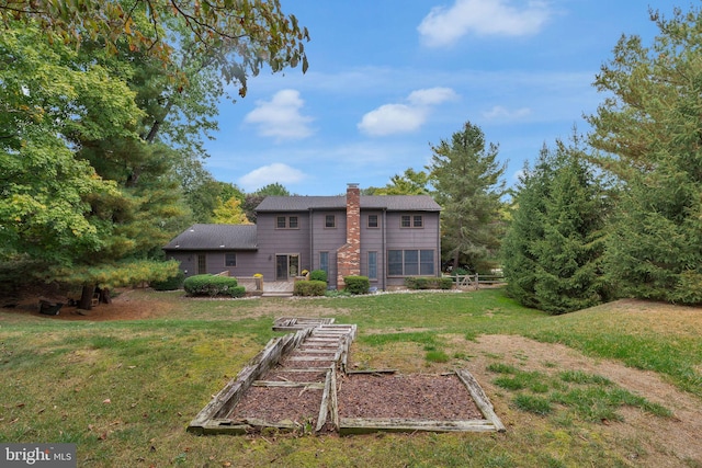 rear view of house featuring a lawn