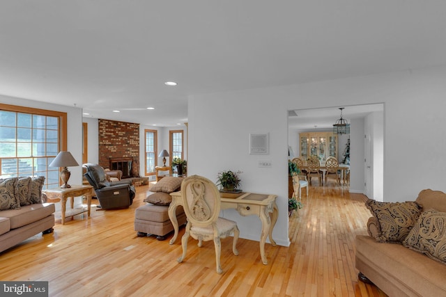 living room with light hardwood / wood-style flooring and a brick fireplace