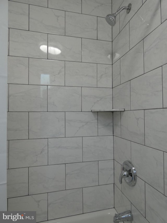 room details with tiled shower / bath combo