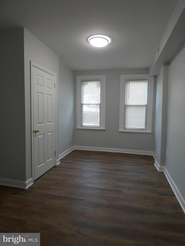 unfurnished room with dark hardwood / wood-style flooring