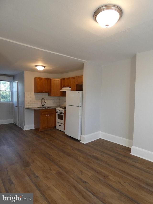 kitchen featuring decorative backsplash, white appliances, dark hardwood / wood-style flooring, and sink