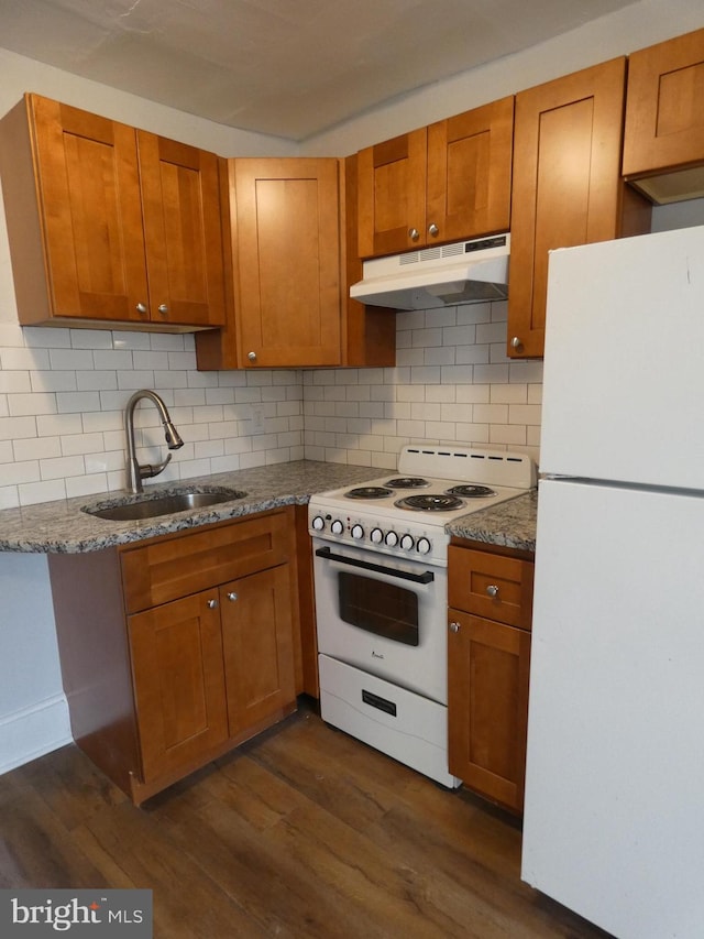 kitchen with decorative backsplash, white appliances, sink, and dark hardwood / wood-style flooring