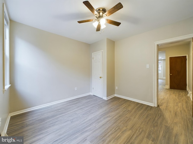 spare room with ceiling fan and dark wood-type flooring