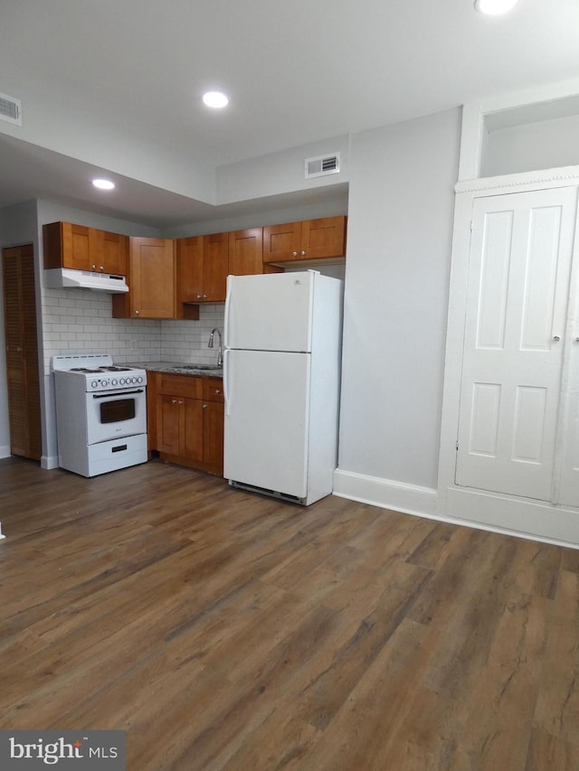 kitchen with white appliances, dark hardwood / wood-style floors, tasteful backsplash, and sink