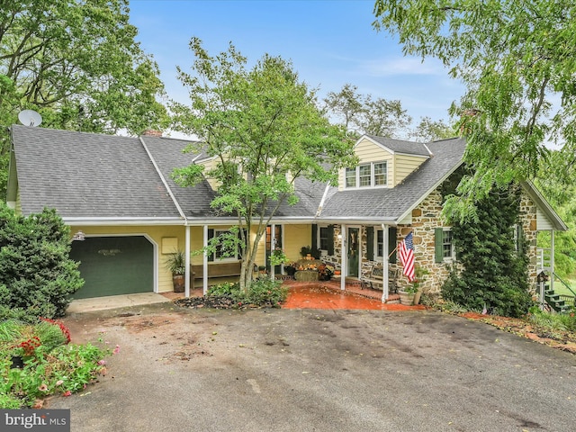 new england style home with a garage and covered porch