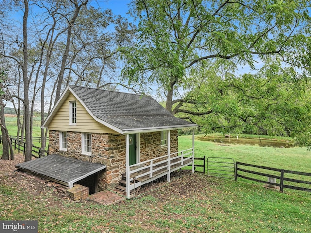 1414 Little Ln, Seven Valleys, PA 17360 - view of side of property with roof with shingles, stone siding, fence, and a lawn